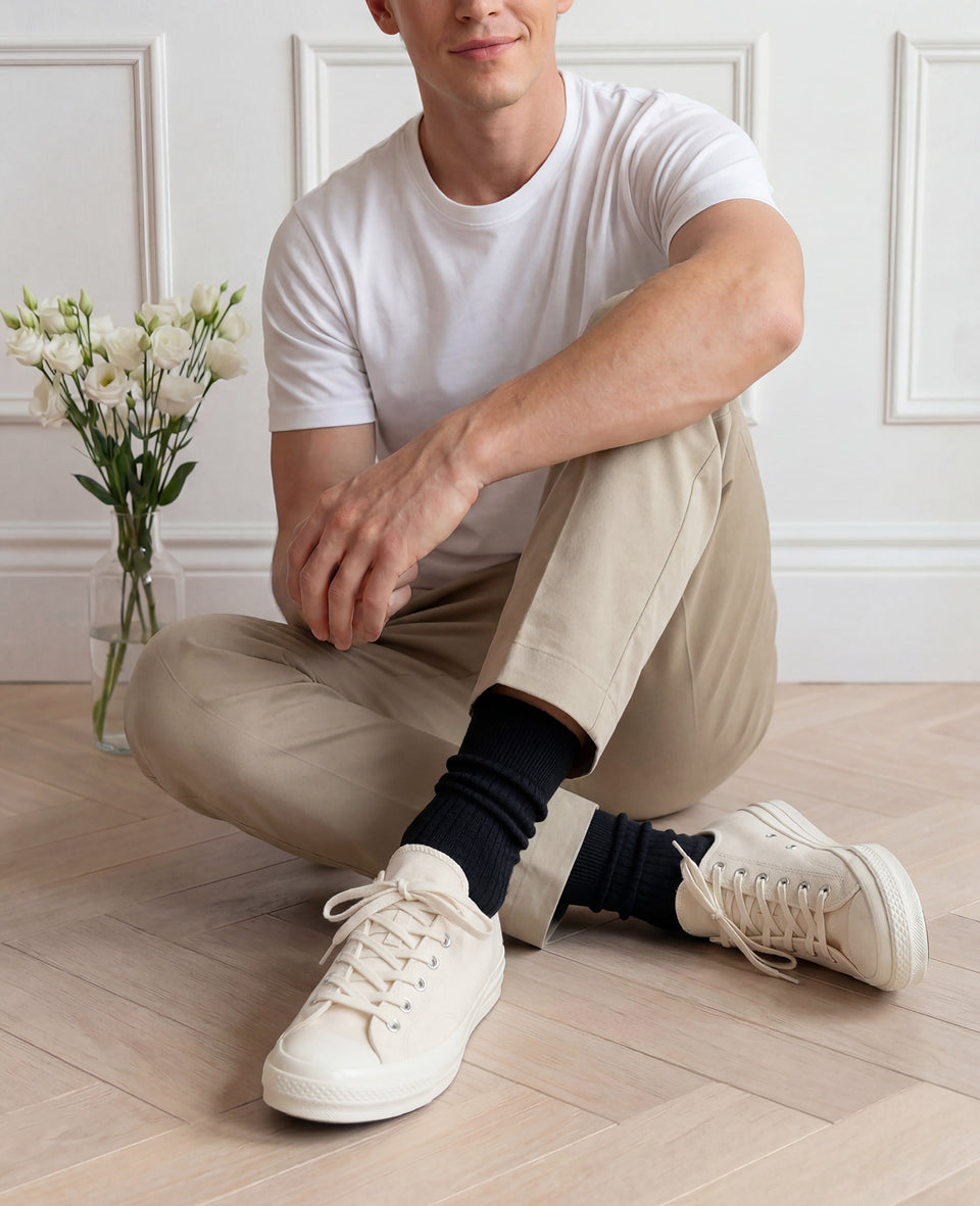 Man in white t-shirt and cream chinos wearing black Democratique Originals Fine Rib socks with off-white Converse Chuck 70 sneakers, premium organic cotton mens style