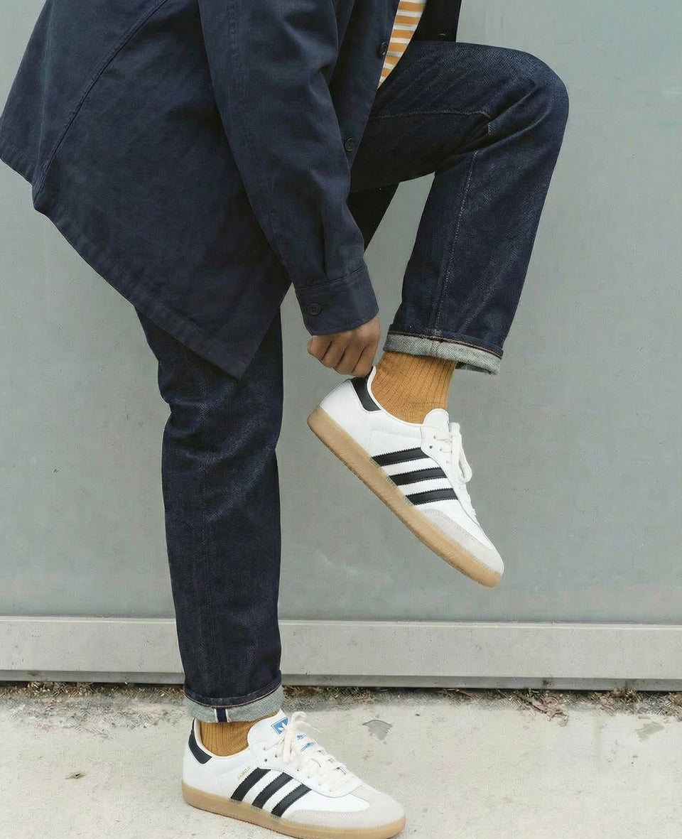 Premium old gold rib socks styled with dark denim and white sneakers, modern menswear look with organic cotton mustard socks designed in Copenhagen